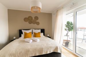 ein Schlafzimmer mit einem großen Bett mit gelben Kissen in der Unterkunft DWELLSTAY - Modernes Apartment I 55qm I 2 Zimmer I Küche I Bad I Terrasse I TV I Netflix in Bad Hersfeld