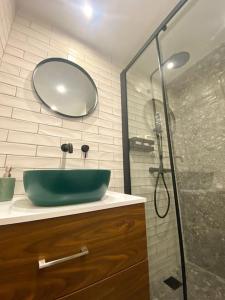 a bathroom with a green sink and a shower at Piraeus Apartment for rent in Piraeus