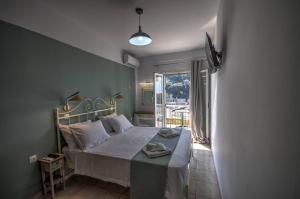 a bedroom with a bed in a room with a window at Astacos Studios in Paleokastritsa