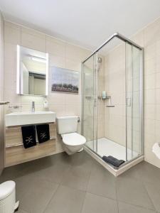 a bathroom with a shower and a toilet and a sink at Phoenix Studio - Haus Astral - Zermatt in Zermatt