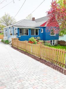 una casa azul con una valla de madera delante de ella en State Street Cottage, Suite 2, en Pullman