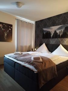 a bedroom with a large bed with towels on it at Stadthotel Deggendorf in Deggendorf