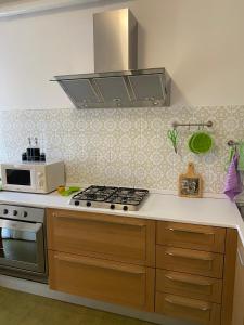 uma cozinha com um fogão e um micro-ondas em Green House Caldiero em Caldiero