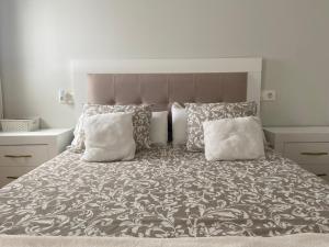 ein Schlafzimmer mit einem großen Bett mit weißen Kissen in der Unterkunft Ático nuevo en Arteixo con plaza de garaje in Arteixo