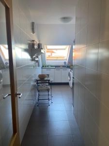 una pequeña cocina con mesa y ventana en Ático nuevo en Arteixo con plaza de garaje, en Arteixo