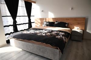 1 dormitorio con 1 cama grande y cabecero de madera en Villa Castella en Skopie