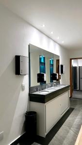 a bathroom with two sinks and a large mirror at Capsula Hotel Sao Paulo - Paulista in Sao Paulo