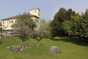 a garden with trees and a building in the background at Al Castello Bed and Breakfast in Cornate dʼAdda