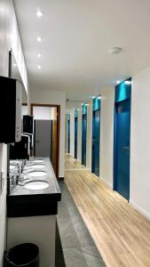 a bathroom with a row of sinks and mirrors at Capsula Hotel Sao Paulo - Paulista in Sao Paulo