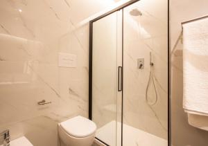 a white bathroom with a shower and a toilet at Corso Vittorio B&B in Pescara