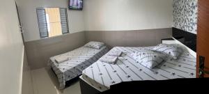1 Schlafzimmer mit 2 Betten und einem Fenster in der Unterkunft Hotel Ellos in Itaquaquecetuba