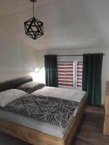 a bedroom with a large bed with green curtains at Apartmány pri Jaskyni - Bystrá in Bystrá