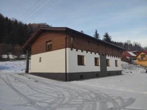 ein kleines Haus im Schnee mit in der Unterkunft Apartmány pri Jaskyni - Bystrá in Bystrá