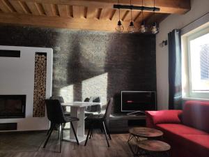 ein Wohnzimmer mit einem roten Sofa und einem Tisch in der Unterkunft Apartmány pri Jaskyni - Bystrá in Bystrá