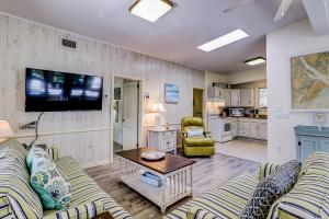 a living room with couches and a flat screen tv at Moonshell 3 in Hilton Head Island