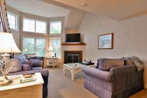 a living room with two couches and a fireplace at Unit 207 2 BDRM 2 BA condo in Birchwood +16 photos