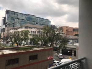 a view from a balcony of a city with buildings at Chic, Serviced one Bedroom Apartment in Rosebank in Johannesburg