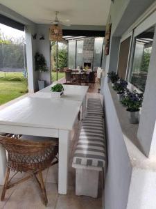 een witte tafel en stoelen op een patio met een tafel bij HARAS SANTA MARIA in Belén de Escobar