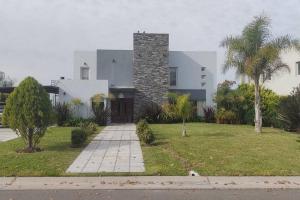 una casa con una chimenea de piedra a un lado en HARAS SANTA MARIA en Belén de Escobar