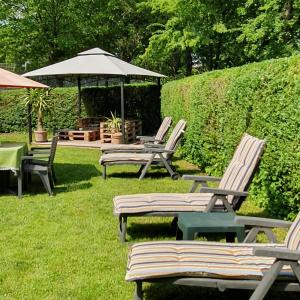 a group of chairs and tables and an umbrella at Haus Bethania Ferienwohnung grande plus in Bad Kissingen