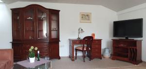 a living room with a tv and a wooden cabinet at Haus Bethania Ferienwohnung grande plus in Bad Kissingen