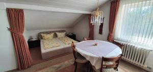 a bedroom with a table and a bed and a window at Haus Bethania Ferienwohnung grande plus in Bad Kissingen