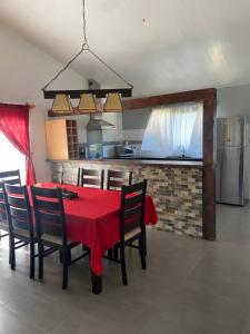 a dining room with a red table and chairs at Las Cholas in La Paloma