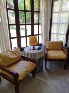Habitación con 2 sillas y mesa con lámpara. en HIPOCAMPO 38 en Villa Gesell