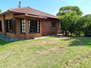 una pequeña casa de ladrillo con un patio de hierba delante de ella en HIPOCAMPO 38 en Villa Gesell