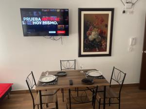 une table en bois avec des chaises et une télévision murale. dans l'établissement (12) Depto con inmejorable ubicación Miraflores, à Lima 9 autres photos