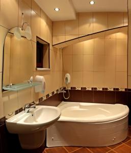 a bathroom with a sink and a toilet and a tub at Hotel Berito in Momchilgrad