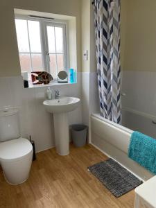 uma casa de banho com um lavatório, uma banheira e um WC. em Stunning Large Detached Gloucester, 4 beds, 3 bedroom, 2 bathroom property, Nr Chelt, The Docks and Quays sleeps 6 em Gloucester