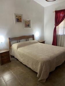 a bedroom with a bed and two tables and a window at Las Cholas in La Paloma