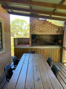 a wooden table in a patio with a fireplace at Las Cholas in La Paloma