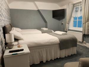 ウェイマスにあるLichfield Houseのベッドルーム1室(ベッド2台、ランプ付きテーブル付)