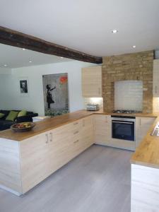 a kitchen with wooden cabinets and a stove top oven at Barn in beautiful Countyside in Watford