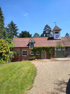 a brick house with a clock tower on top of it at Barn in beautiful Countyside in Watford