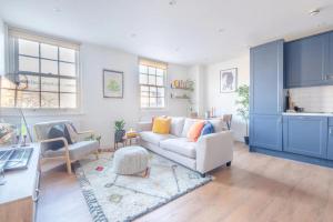 a living room with a white couch and blue cabinets at Modern and Beautiful 2 Bedroom Flat - Haggerston in London