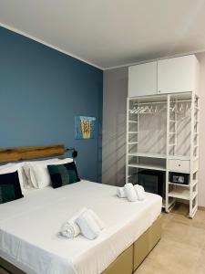 a bedroom with a large white bed with towels on it at Avio Suite in Naples