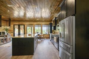 eine Küche mit Küchengeräten aus Edelstahl und einer Holzdecke in der Unterkunft Skippin` Rocks in Broken Bow