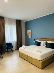 a bedroom with a large bed with a blue wall at Avio Suite in Naples