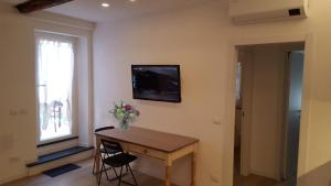 um quarto com uma mesa e uma televisão na parede em La Terrazza del Borgo em Lavagna