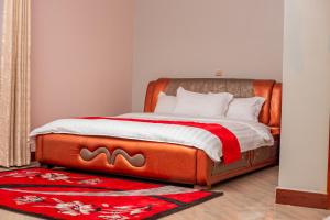 a bedroom with a bed with a red blanket at Das Berliner Hotel in Kampala