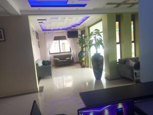 una sala de estar con un jarrón grande en el suelo en Das Berliner Hotel en Kampala