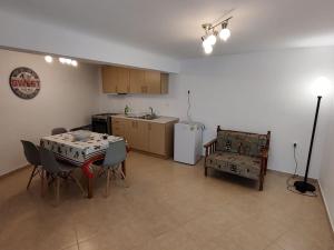 een woonkamer met een tafel en stoelen en een keuken bij Kostas' House in Piraeus