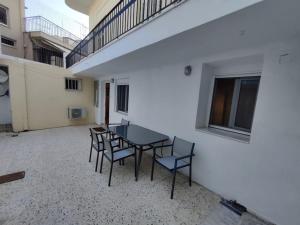 een patio met een tafel en stoelen in een gebouw bij Kostas' House in Piraeus