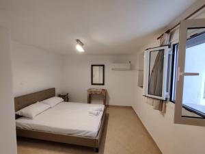 a small bedroom with a bed and a window at Kostas' House in Piraeus