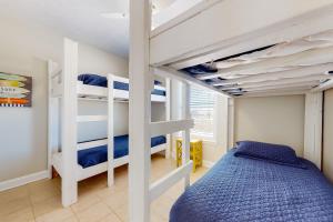ein Schlafzimmer mit Etagenbetten und einem blauen Bett in der Unterkunft Midsummer Solstice in Dauphin Island