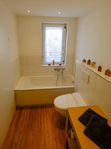a bathroom with a tub and a toilet and a window at Barbarossa Suite in Erfurt