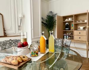 a glass table with a bowl of fruit and orange juice at Hotel Particulier La Defense - Boutique Hotel Paris in Puteaux